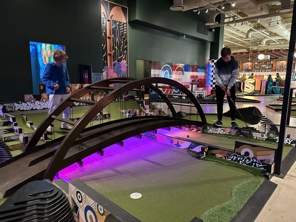 Children playing mini golf indoors at the Dirdie Birdie