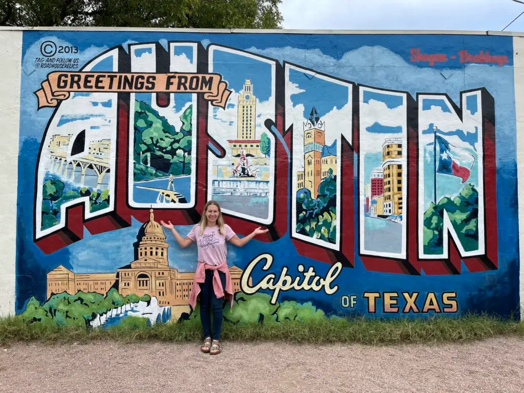 Mom stands in front of the iconic "Greeting From Austin" mural