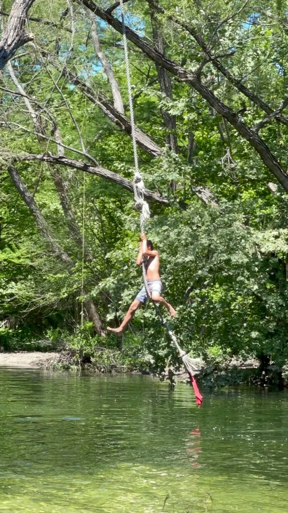 A child swings from a rope at St. Edwards Trail