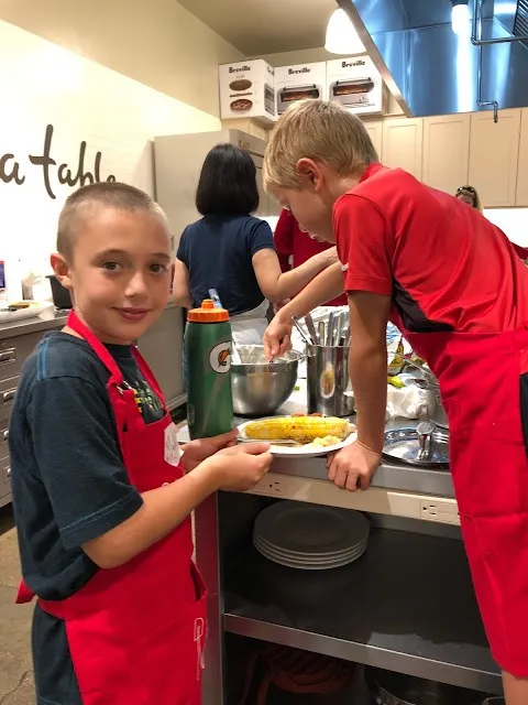 Children in aprons preparing food at the Sur La Table cooking camp