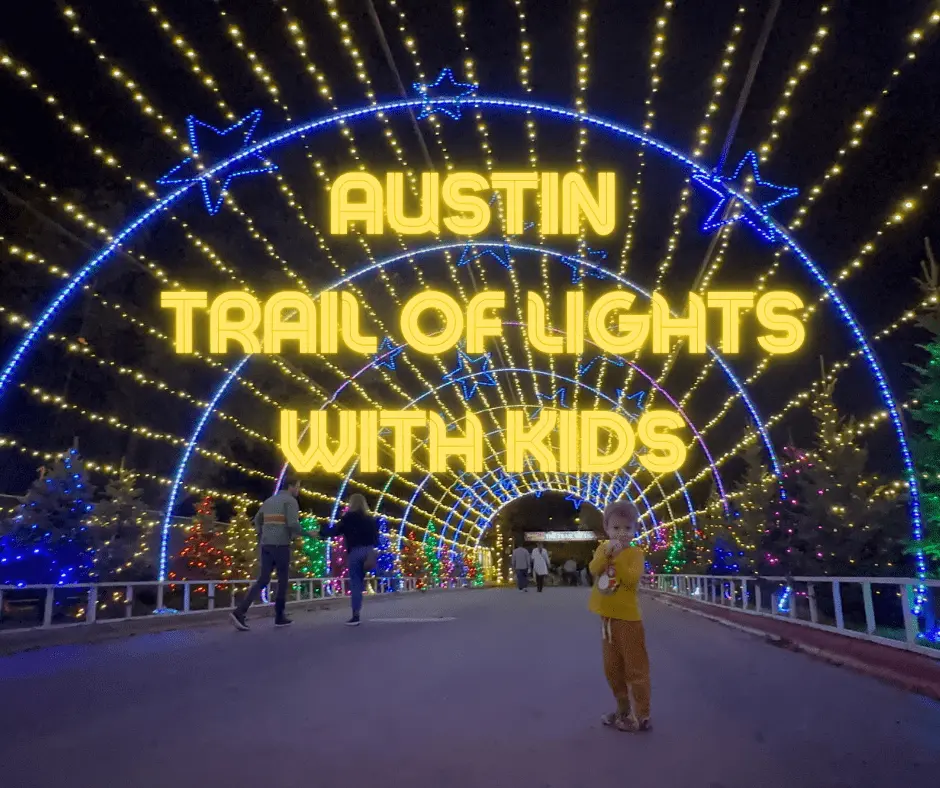 Child poses under the tunnel of lights at Austin Trail of Lights