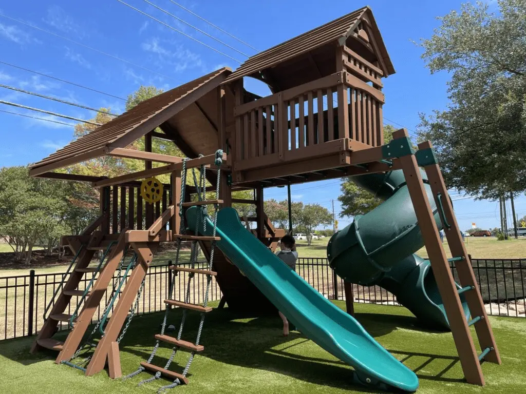 Play structure on turf with slides at Oz. Tap House